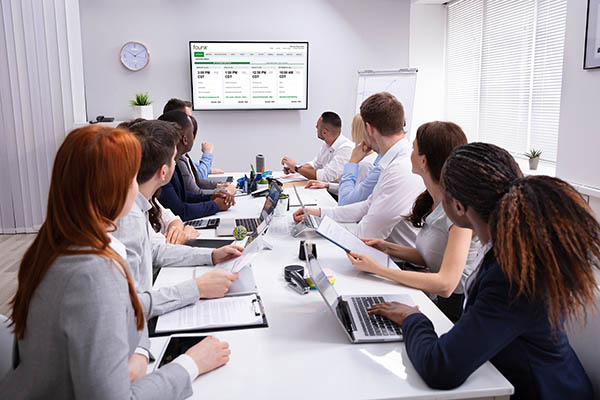 founX-contact-sales-group-in-meeting-with-dashboard-on-televison